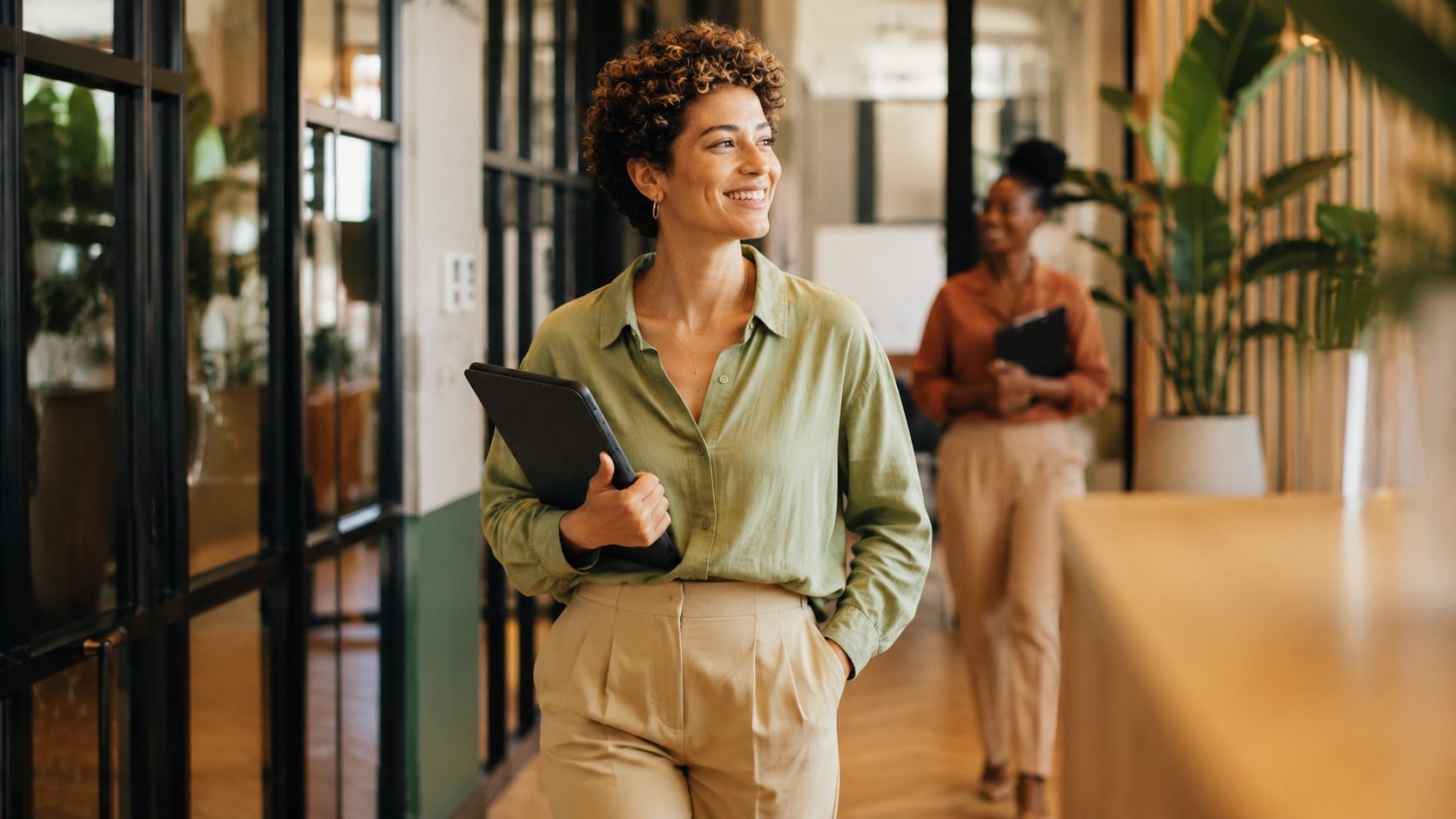 A recruiter walking through the office with a tablet, mid-desk